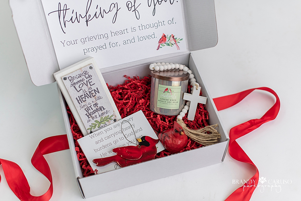 Cardinal themed gift box that includes a Cardinal quote candle, a cross, a Cardinal ornament and a table top quote