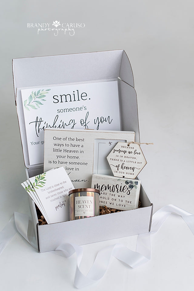 A sympathy gift box of goods for the bereaved heart. Includes a candle, a picture frame, ornament and quote to help anyone who is experiencing loss